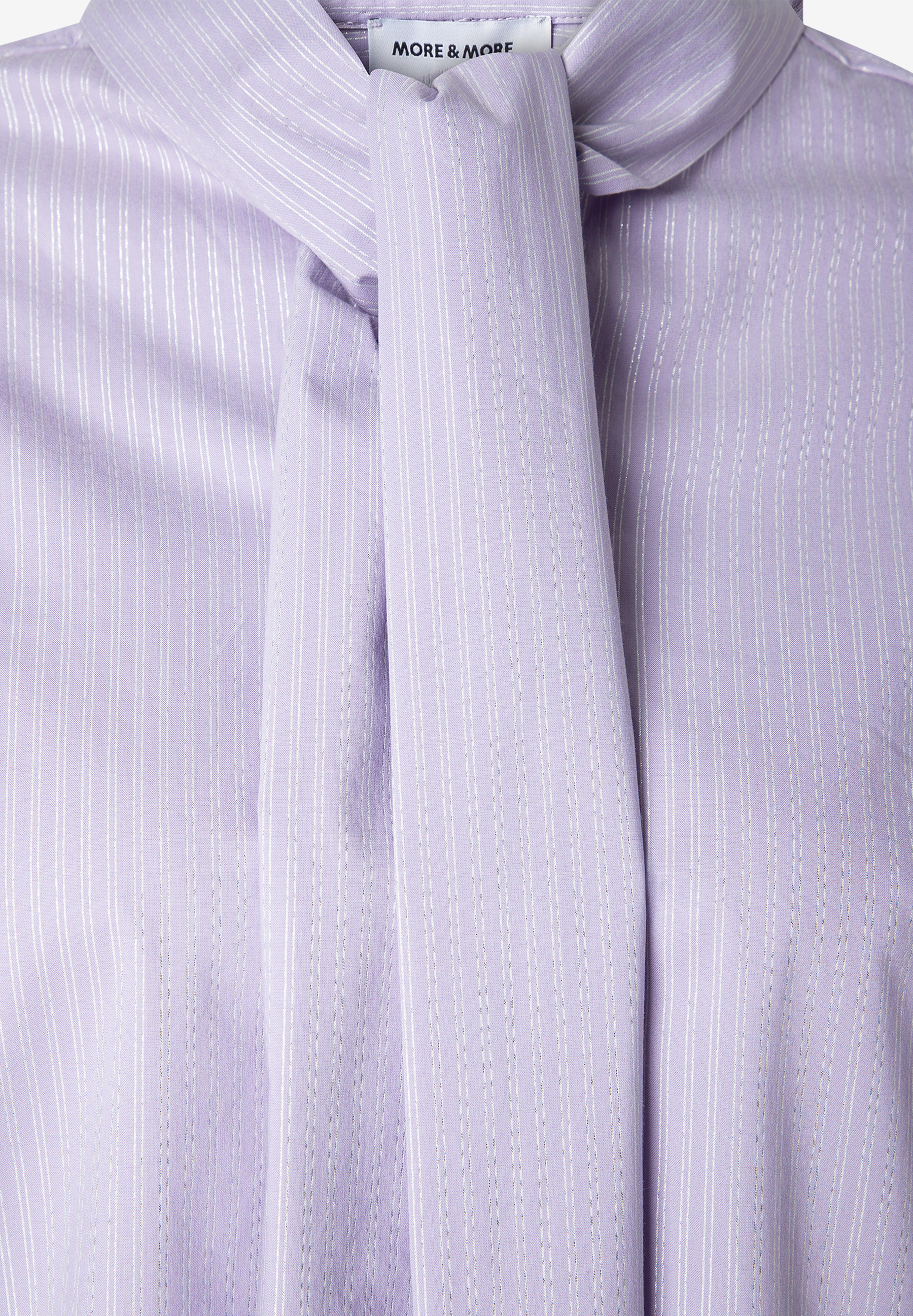 MORE & MORE Bluse: Eine lavendelfarbene Bluse mit Stehkragen und glänzenden, vertikalen Streifen. Der Stehkragen ist zu einer eleganten Schleife gebunden.