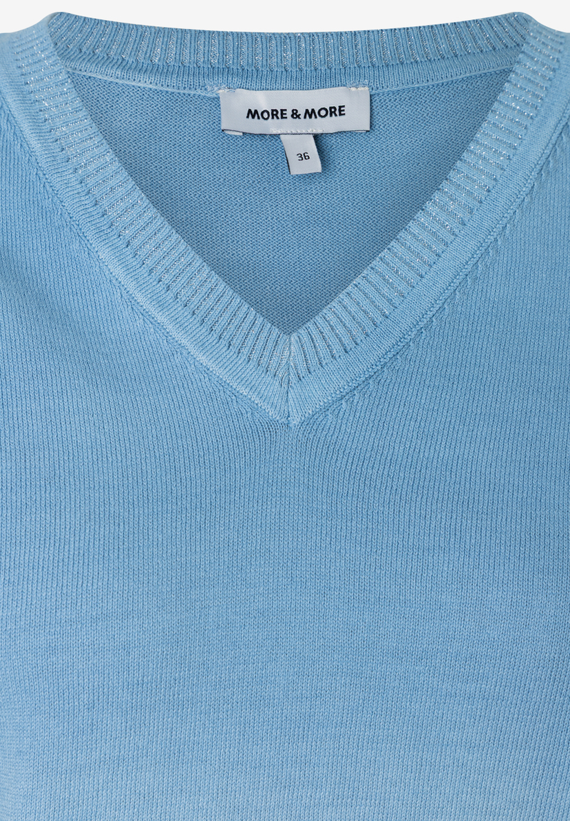 Nahaufnahme eines hellblauen MORE & MORE Strickpullovers mit V-Ausschnitt und Größenetikett. Nahaufnahme eines hellblauen MORE & MORE Strickpullovers mit V-Ausschnitt und Größenetikett.
